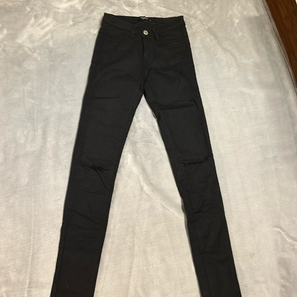 Black skinny jeans, distressed denim at knees